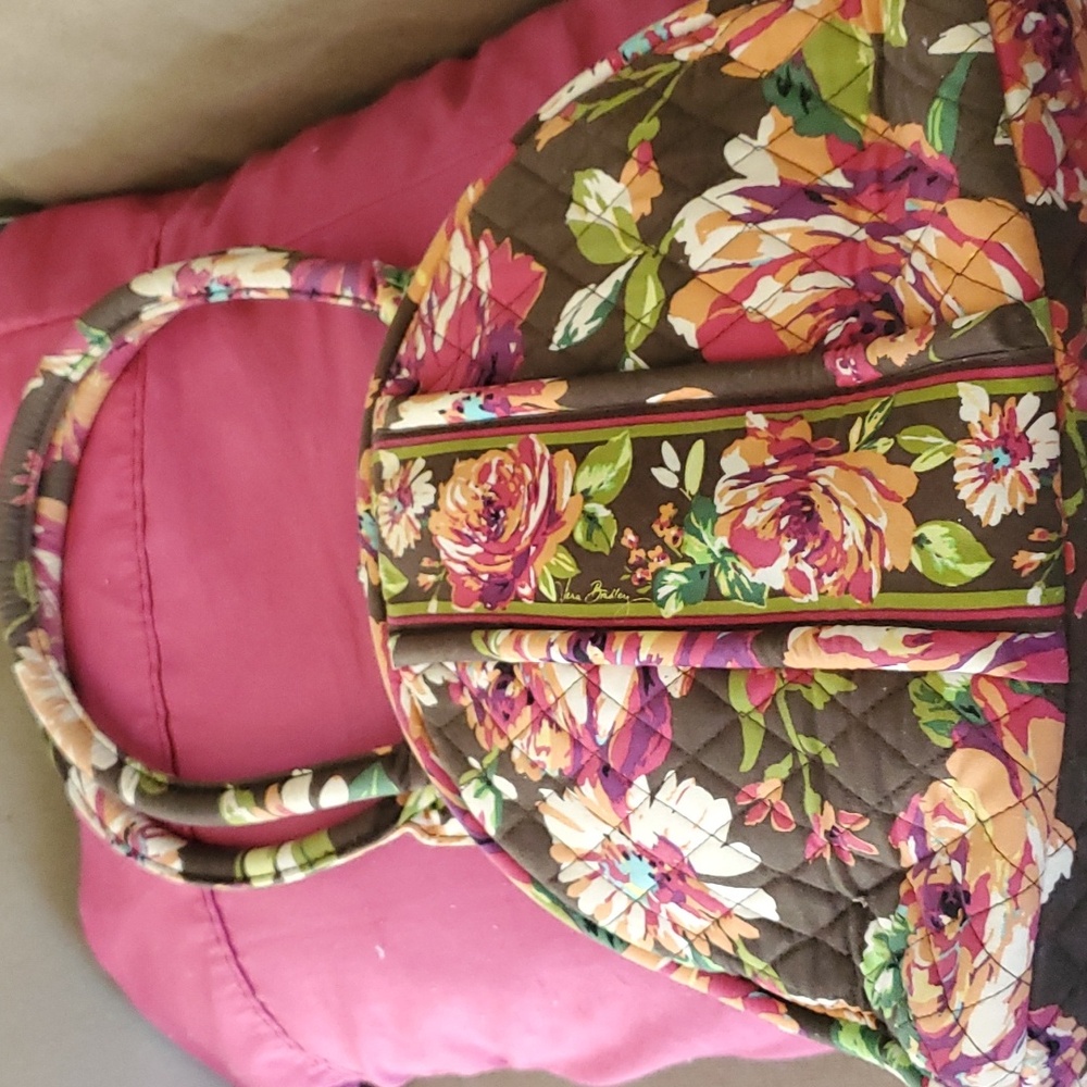 Vera bradley purse with 3 compartments and several pockets inside.